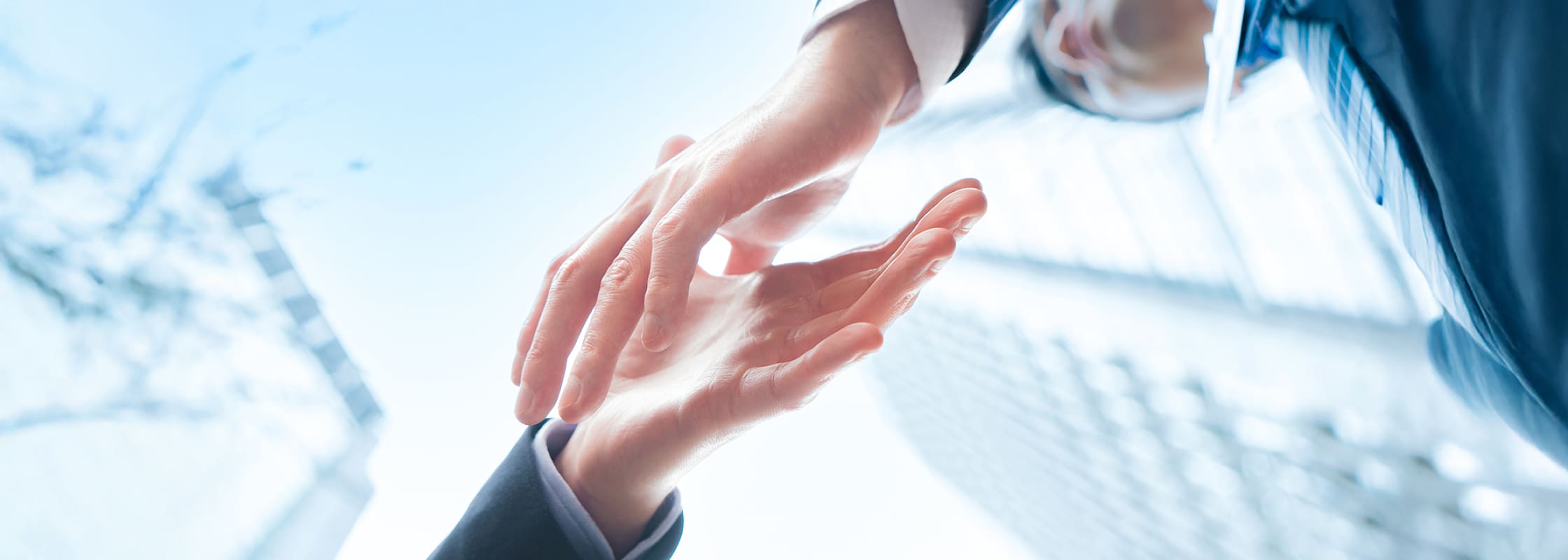 ビジネスパーソンが握手をしようとしている様子